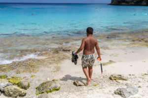 man with snorkeling gear by the beach