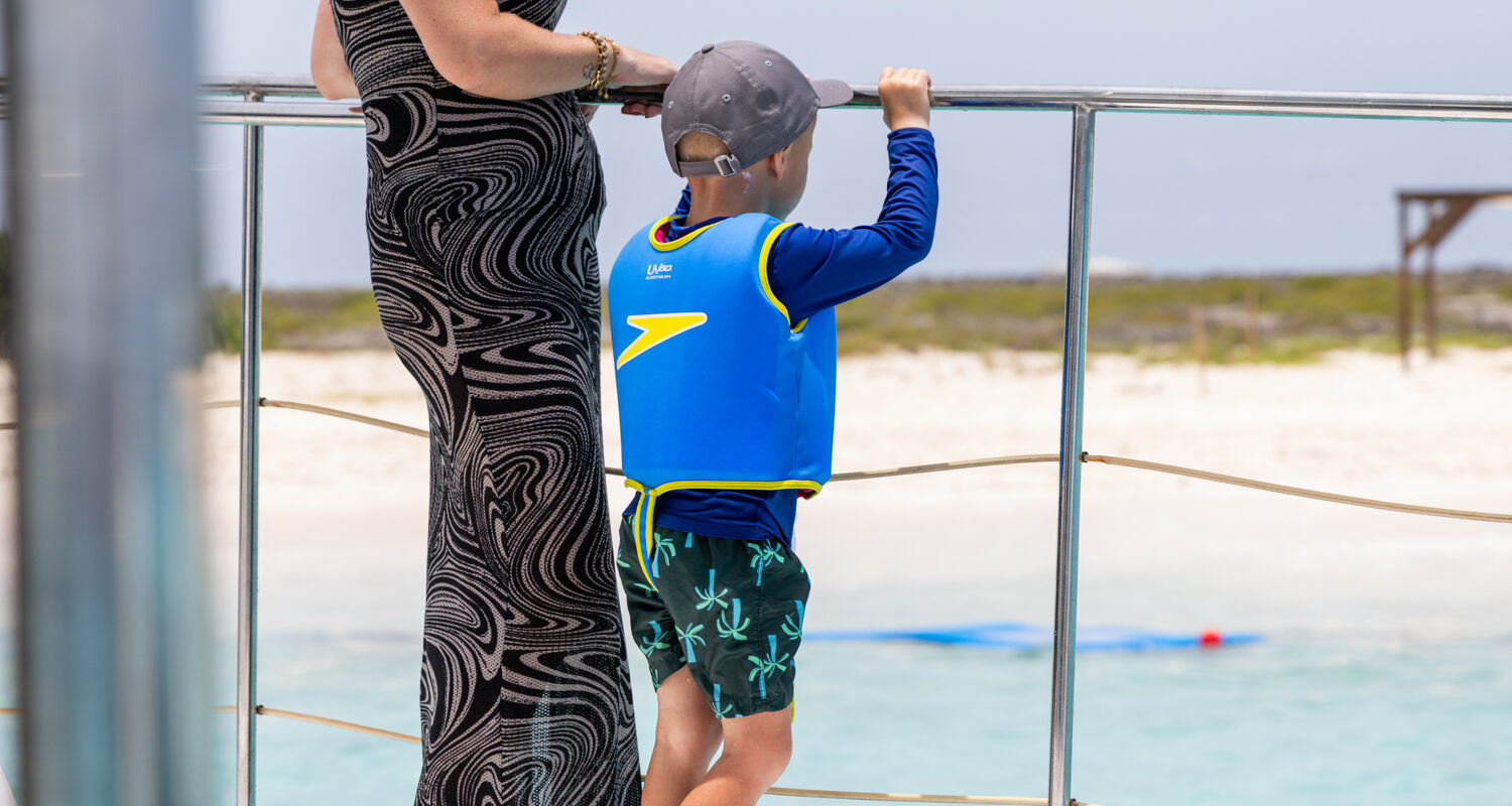 Kid with safety vest on boat